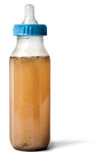 Child's baby bottle filled with dirty, brown water
